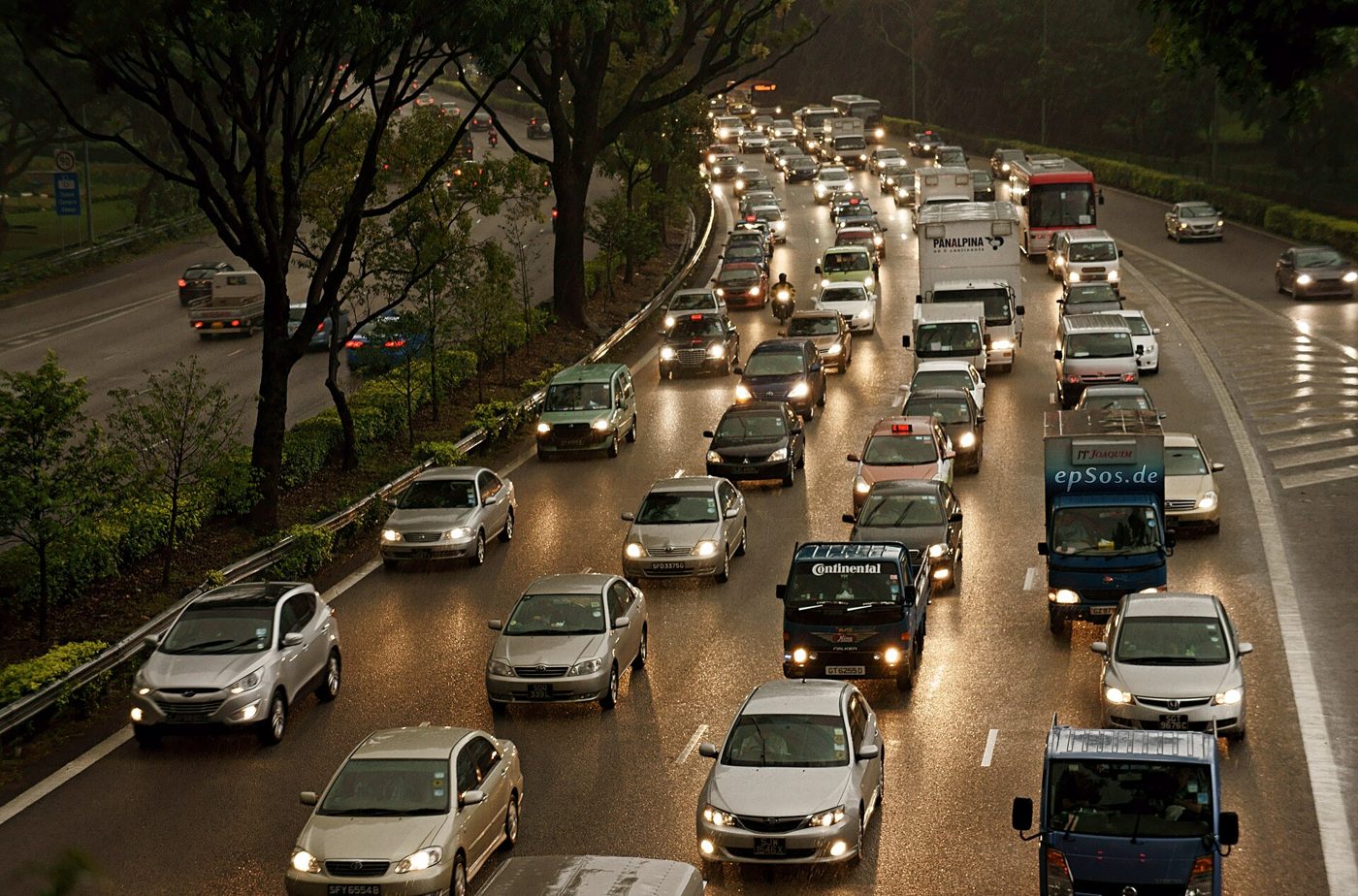 Dense peak-hour traffic queued on an urban arterial at dusk.