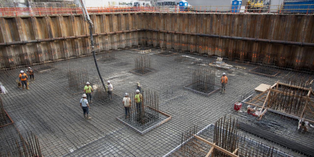 Deep excavation with sheet pile shoring and a mat foundation reinforcement mat being placed